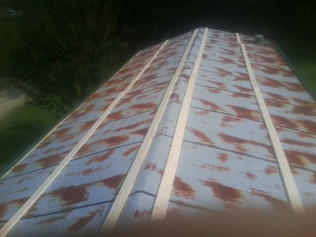 Rusted metal roof panels with new wood purlins before replacement — Storm Damage Roof Repair in Shawboro by Roofing Brothers