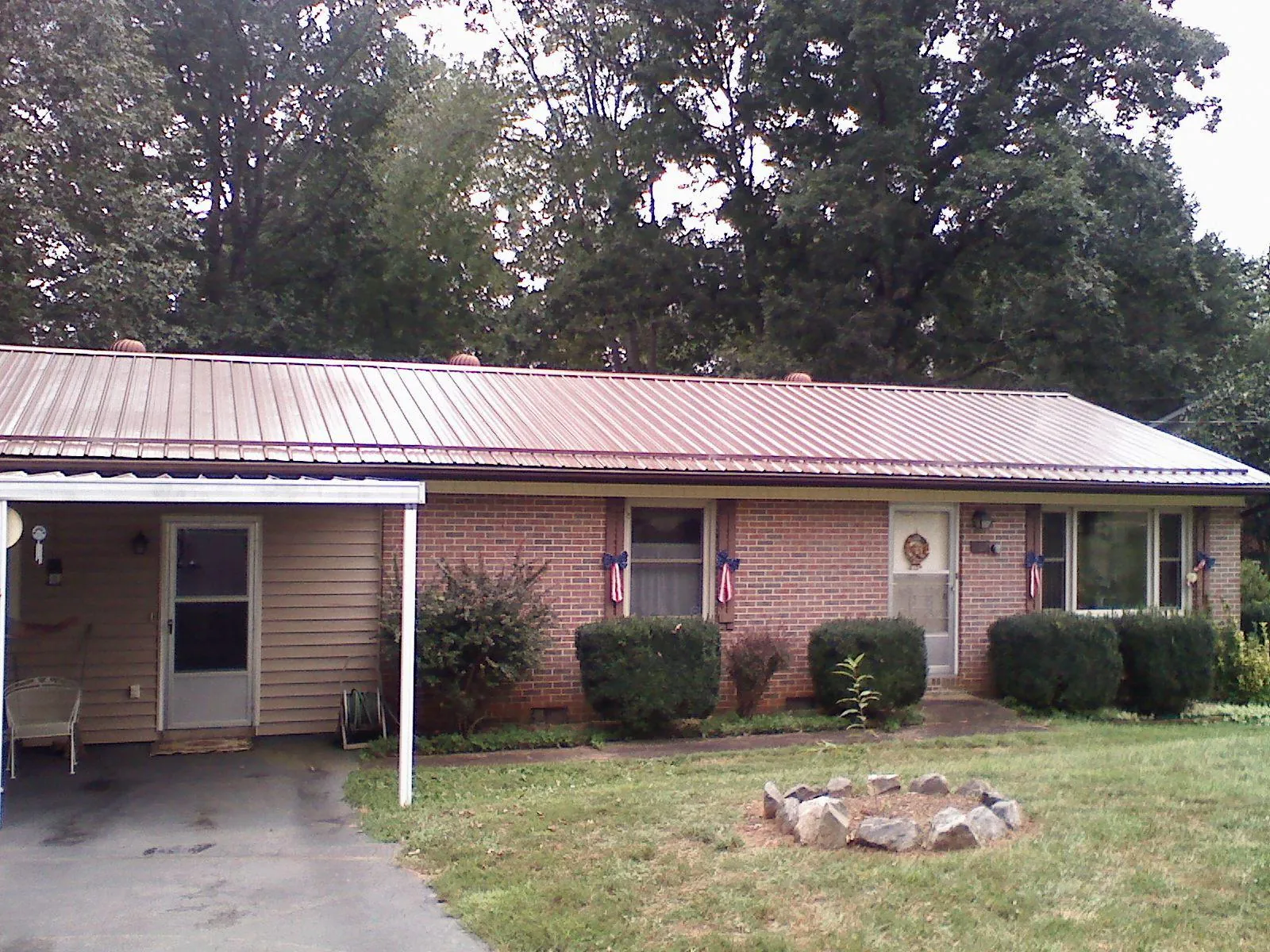 Bronze metal roof and carport on a brick ranch home — Roof Repair work by our crew in Shawboro