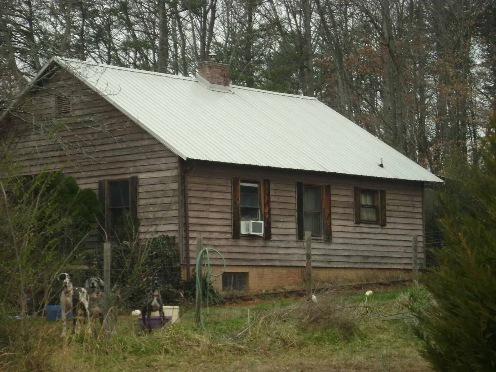 White metal roof on an old wood sided farmhouse, from a Metal Roof Installation job in Shawboro